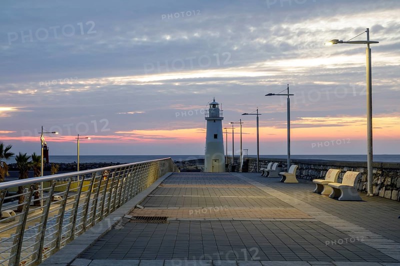 Sunrise with lighthouse at the harbour pier in Porto Maurizio