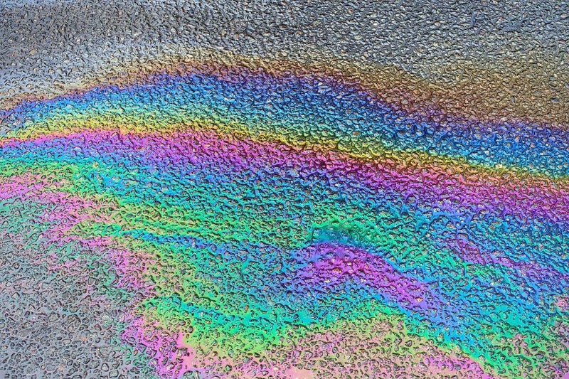 Environmentally harmful traces of oil on an asphalt road