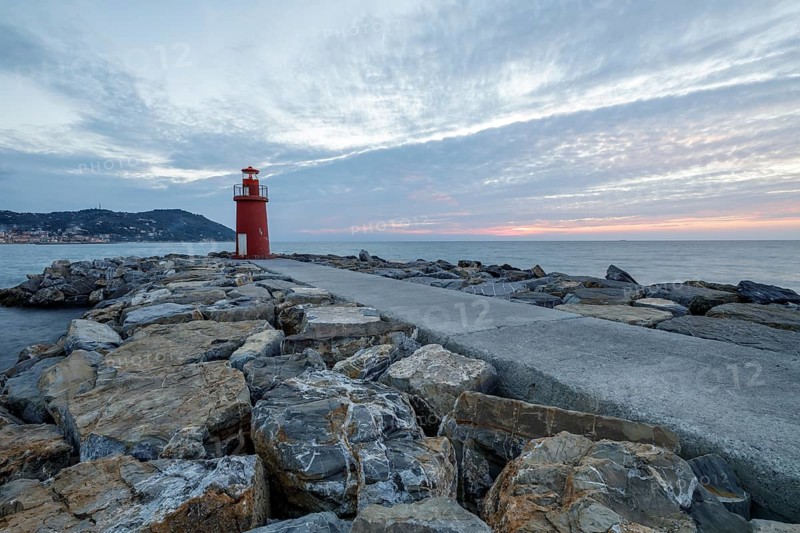 Sunrise with lighthouse at the harbour pier in Porto Maurizio