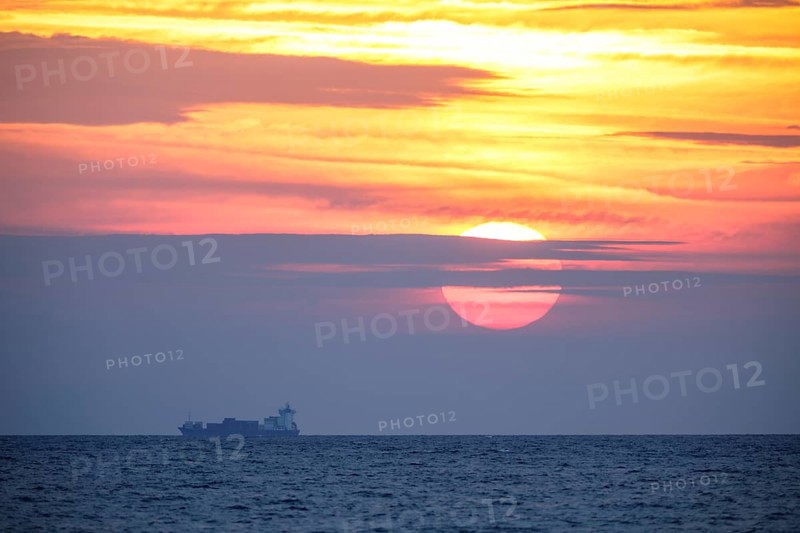 Sunrise with container ship on the Mediterranean Sea in Porto Maurizio