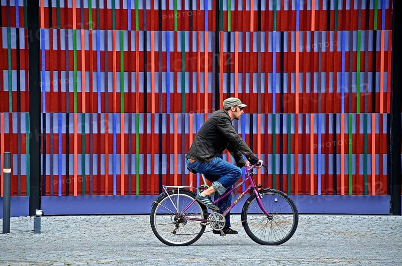 Cyclist in front of the colourful striped facade of the Brandhorst Museum