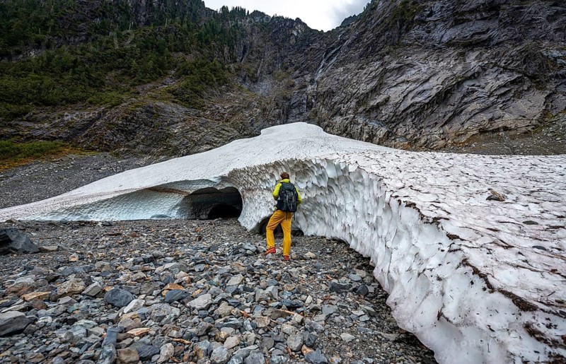 Hikers at the entrance of an ice cave of a glacier