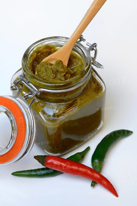 Green Thai curry paste in jar and chillies