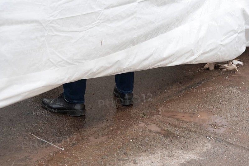 Shoes of a man behind a screen