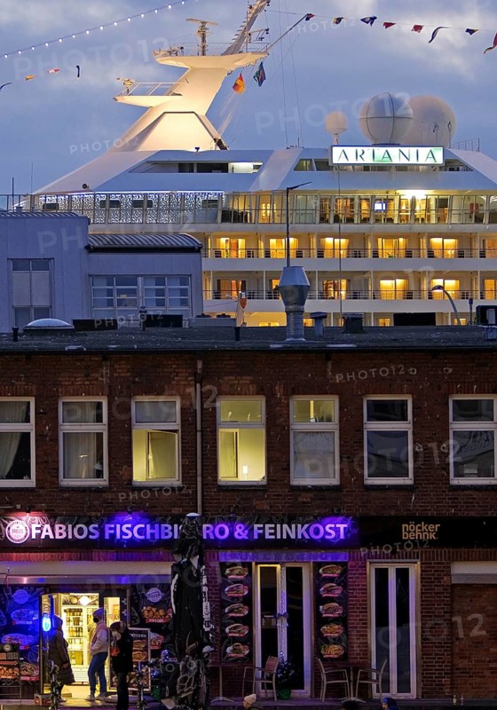 Fish market shops and cruise ship Artania at Hamburg Cruise Center Altona in the evening