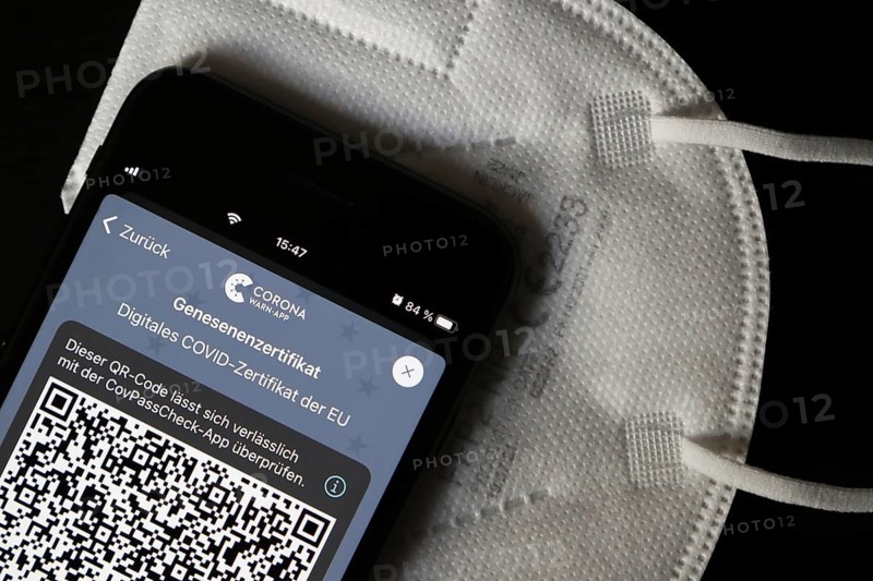 FFP2 mask and iPhone with Corona warning app with QR code for certificate of recovery