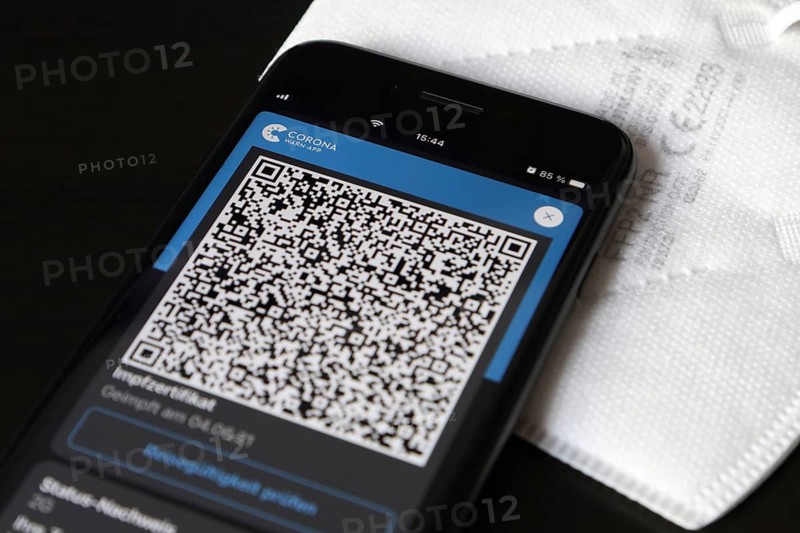 FFP2 mask and iPhone with Corona warning app with QR code for vaccination certificate