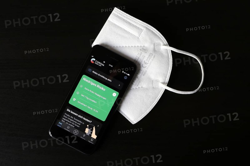 FFP2 mask and iPhone with low-risk Corona warning app