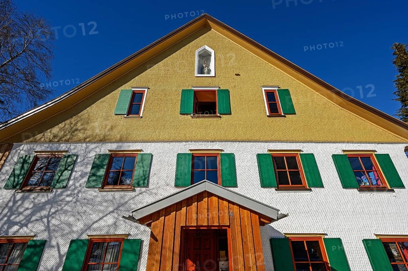Facade with wooden shingles and figure of the Virgin Mary