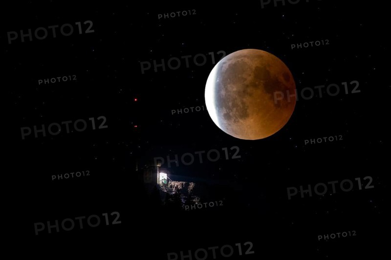 Lunar eclipse over the mountain station of the Saentisbahn