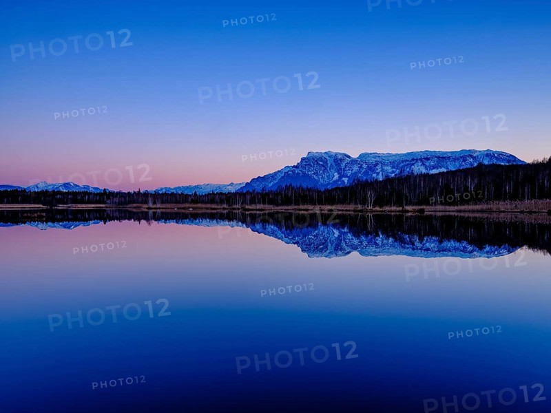 Untersberg at dusk reflected in the moor lake in Ainringer Moor