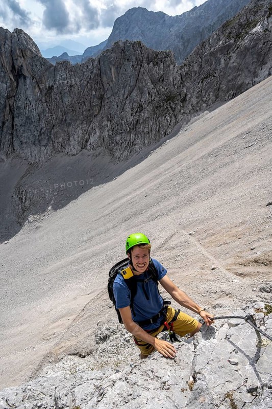 Young man climbing in via ferrata