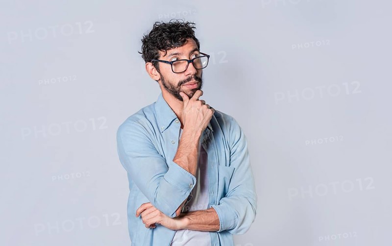 Young man wondering with his hand on his chin on an isolated background