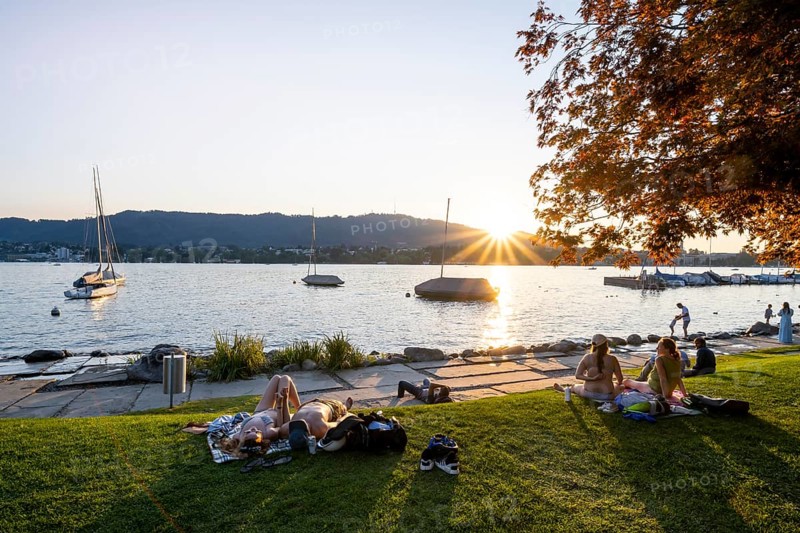 People sunbathing on the shore of Lake Zurich