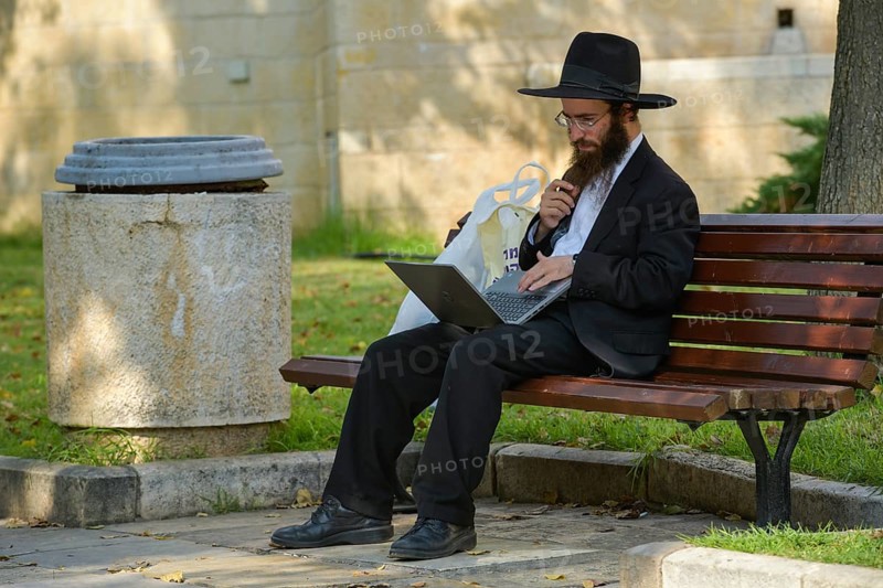 Orthodox Jew in the park with laptop