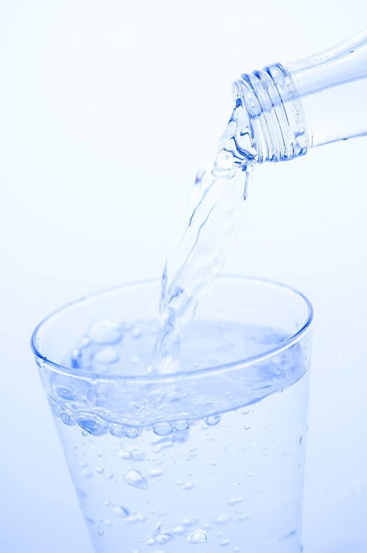 Mineral water is poured into a glass