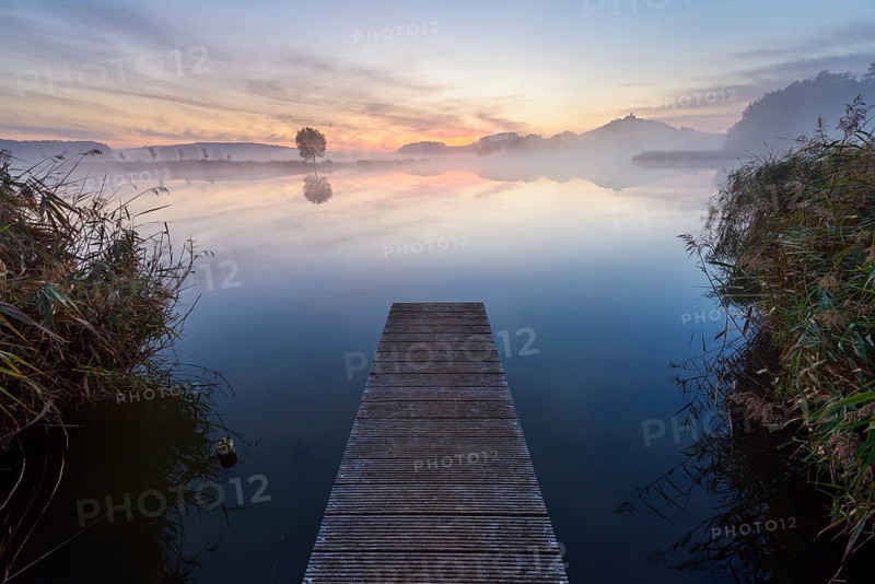 Wooden Jetty with Reflective Sky in Lake at Dawn