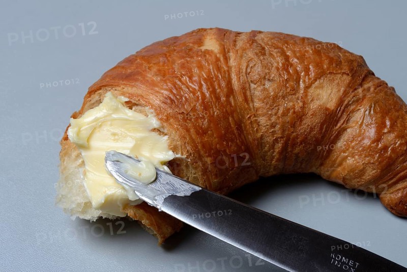 Butter with knife on croissant