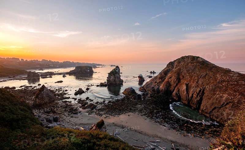View of sea and sandy beach Harris Beach with rocks at sunrise
