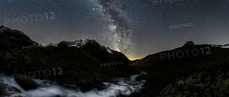 Mountain stream with Winnebachsee hut and Winnebach peaks with starry sky and Milky Way