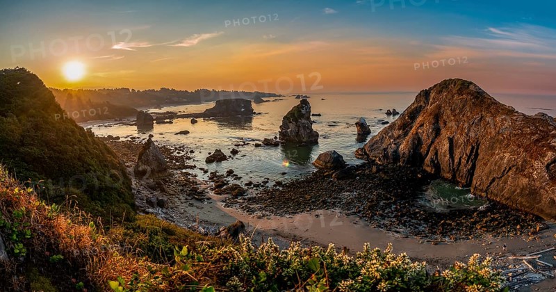 View of sea and sandy beach Harris Beach with rocks at sunrise