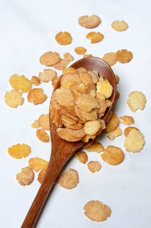 Soy flakes in wooden spoon