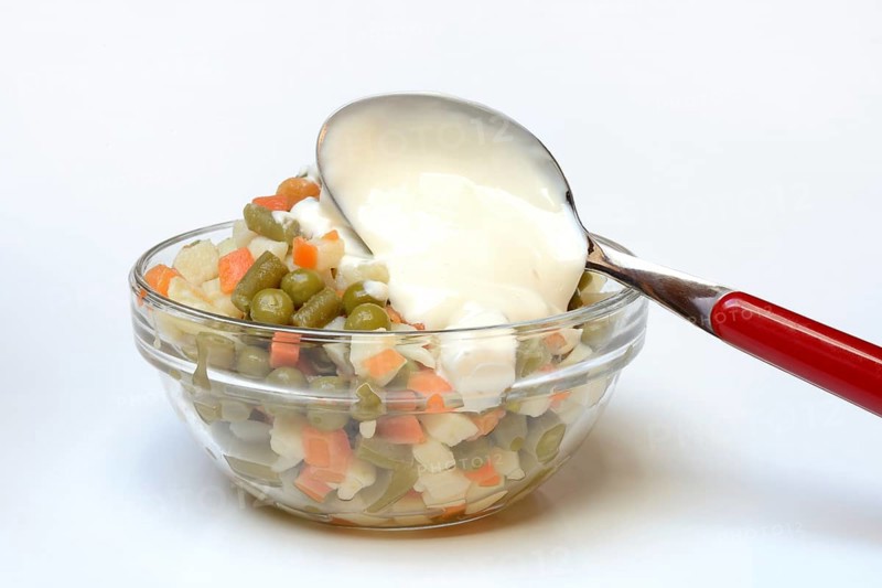 Ingredients for Russian salad and spoon with mayonnaise