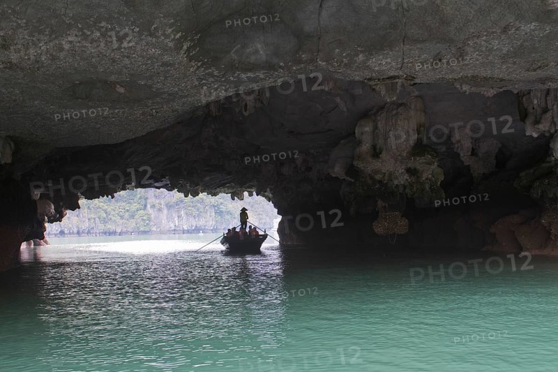 Rowing boat at the rock tunnel in Halong Bay