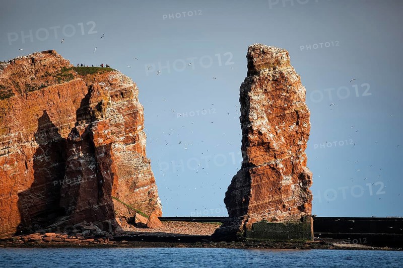 View from the sea to the rocky island of Helgoland with surf pillars Lange Anna and Kleine Anna