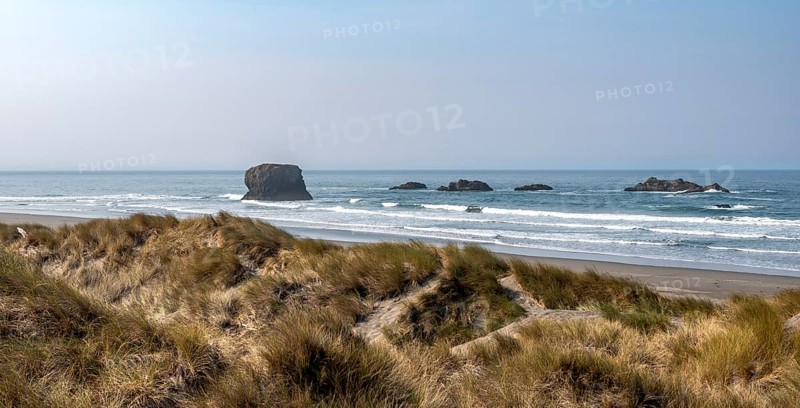 View over sandy beach with dunes and large rocks