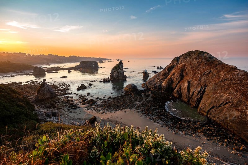 View of sea and sandy beach Harris Beach with rocks at sunrise