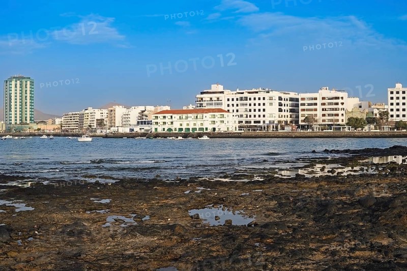 Houses on the harbour promenade with Grand Hotel Arrecife