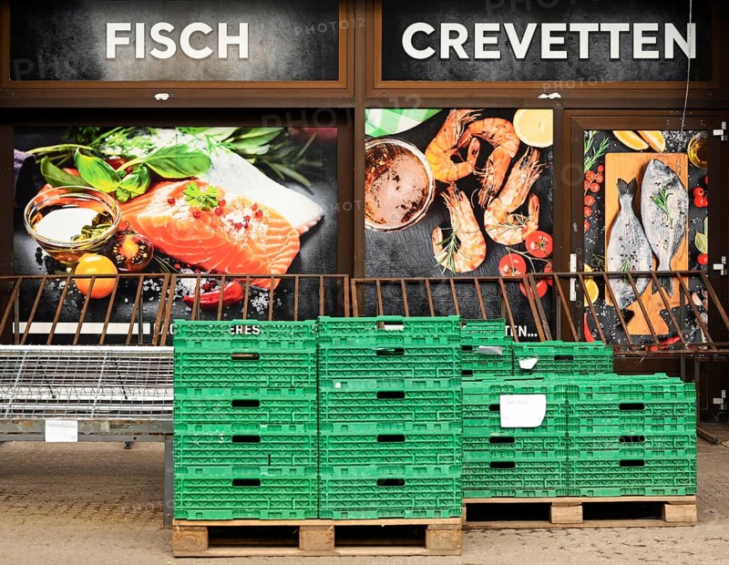 Shop window fish Crevetten in front of it green plastic boxes