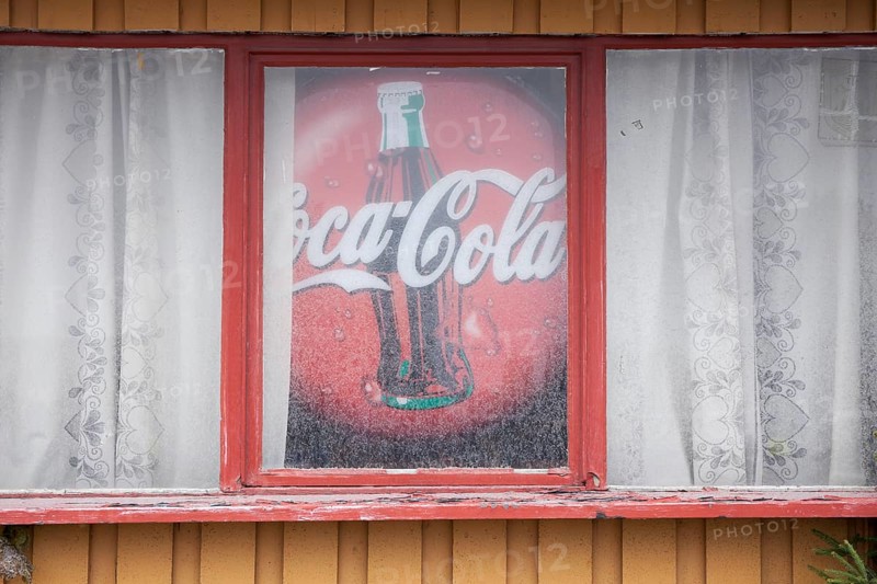 Old advertising sign for Coca-Cola in window