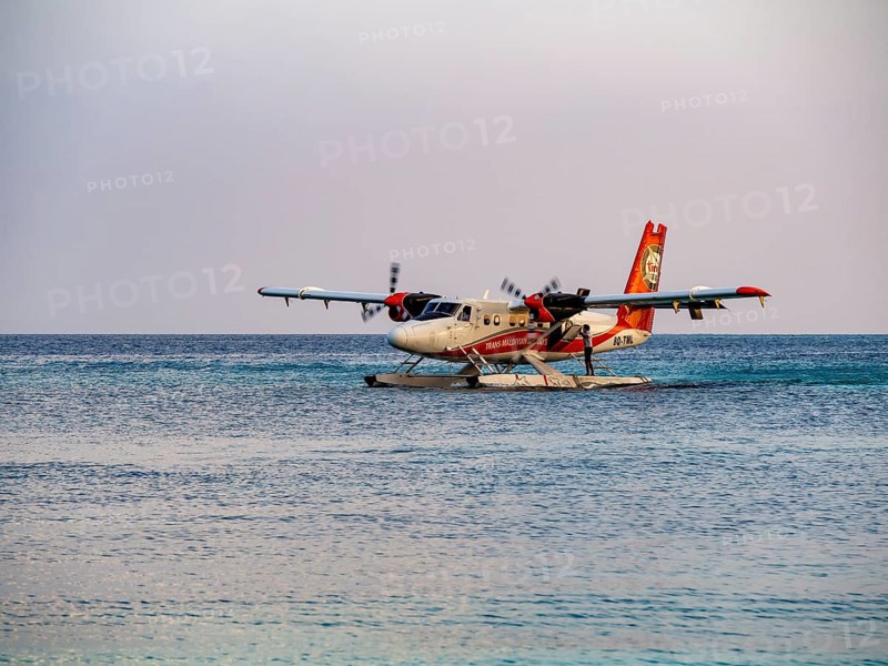 Seaplane landing in a lagoon of a Maldives island