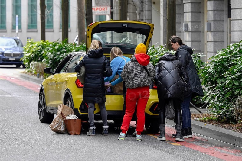 People stow luggage in the car trunk