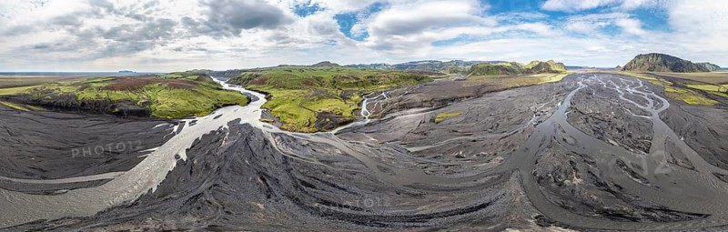 River with fanned out branches through black lava sand