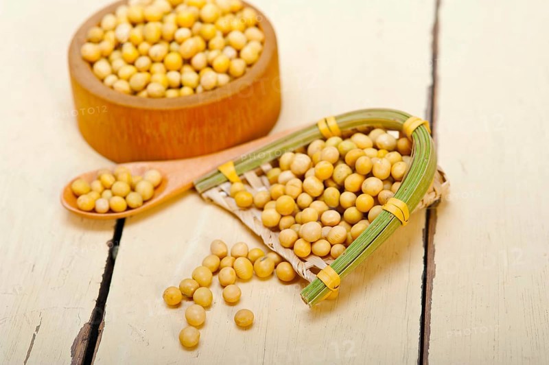 Organic soya beans over rustic wood table macro closeup