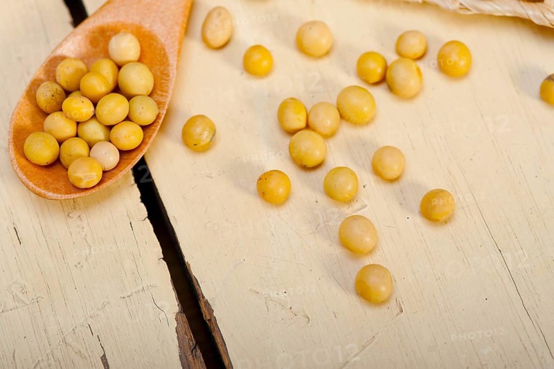 Organic soya beans over rustic wood table macro closeup