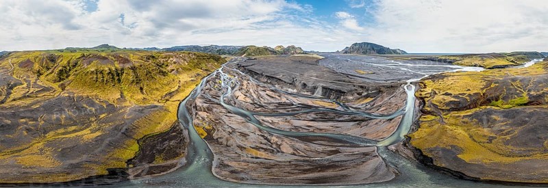 River with fanned out branches through black lava sand