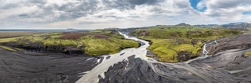 River with fanned out branches through black lava sand