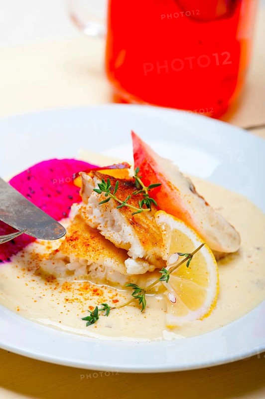 Sea bream orata fillet butter pan fried with fresh peach prune and dragonfruit slices thyme on top