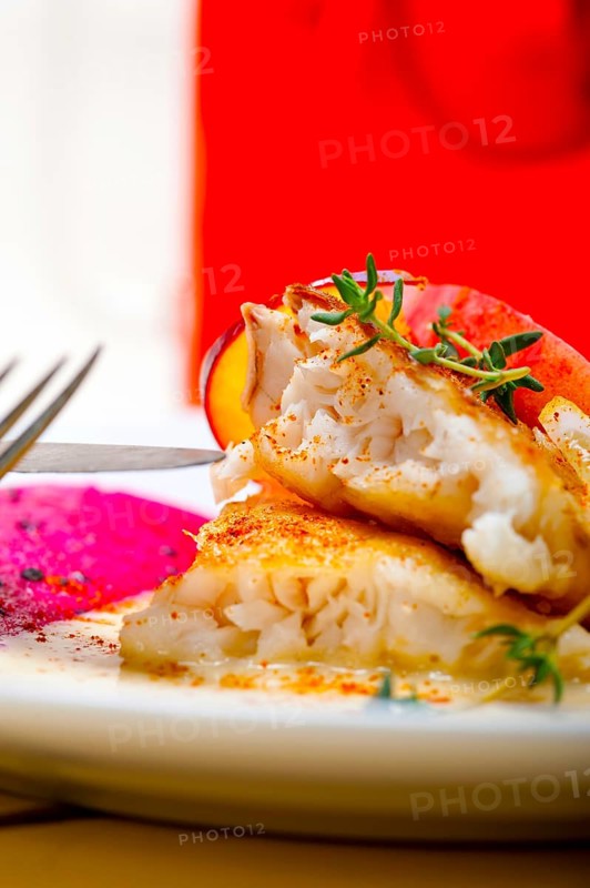 Sea bream orata fillet butter pan fried with fresh peach prune and dragonfruit slices thyme on top
