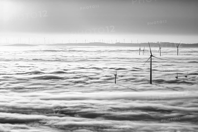 Wind turbines rising from cloud cover