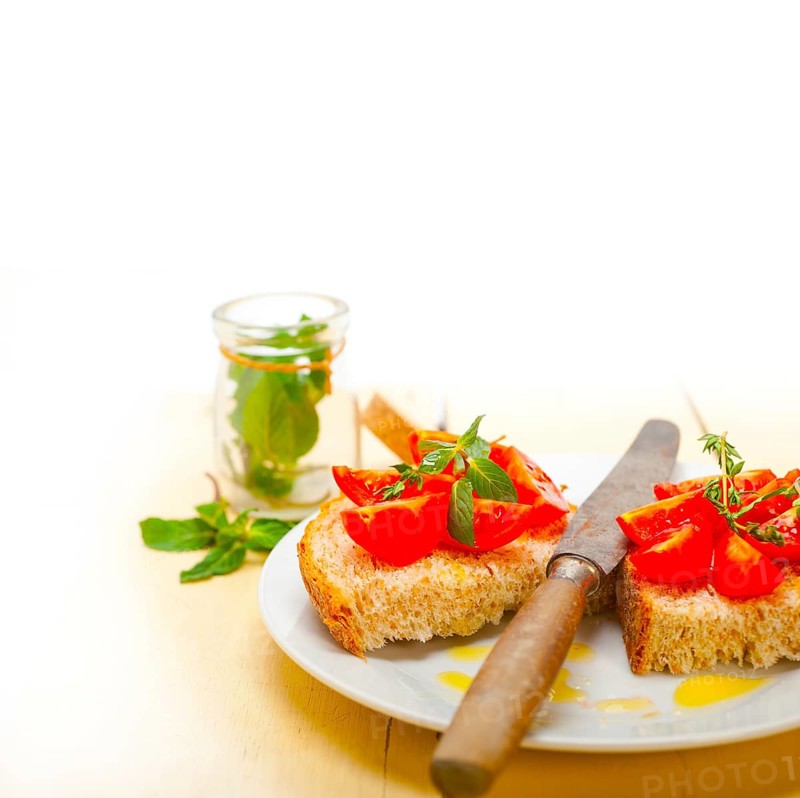 Italian tomato bruschetta with thyme and mint leaves