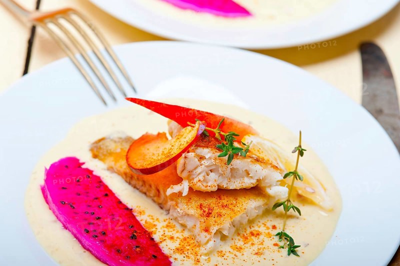 Sea bream orata fillet butter pan fried with fresh peach prune and dragonfruit slices thyme on top