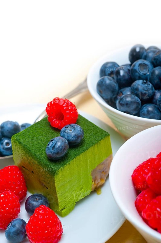 Green tea matcha mousse cake with raspberries and blueberries on top