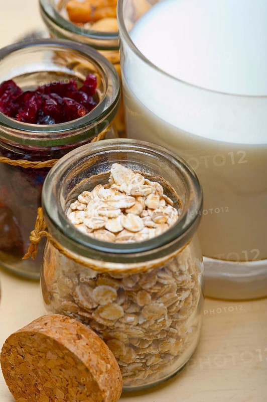 Healthy breakfast ingredients milk oat cashew nuts dried cramberry craisinns