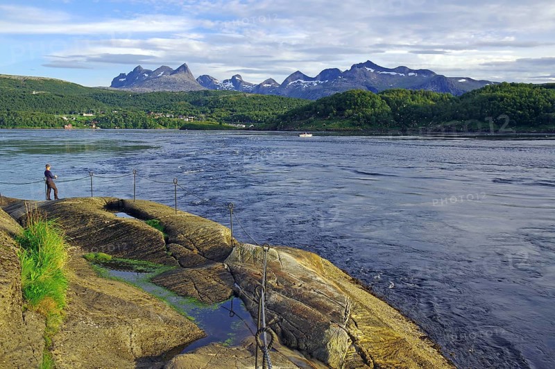 Angler standing on the bank of a fast flowing water