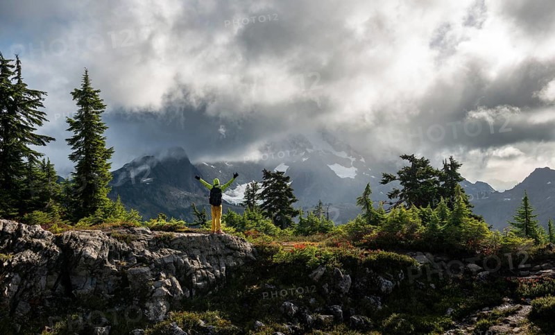Hiker stretches his arms in the air